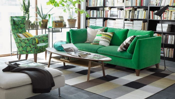غرفة معيشة تحتوي على أريكة باللون الاخضر وكرسي مشجر مع ترابيزة بيضاوية الشكل مودرن