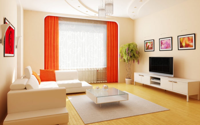 غرفة معيشة تتكون من ركنة باللون الكريمي الفاتح وستائر شيفون باللون الكريمي والبرتقالي