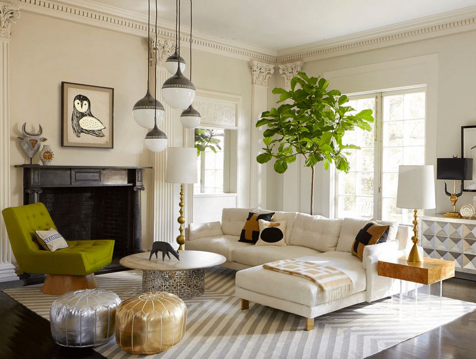 غرفة معيشة مودرن مكونة من ركنة بيضاء وكرسي باللون الاخضر وترابيزة بتصميم عصري شيك جداً