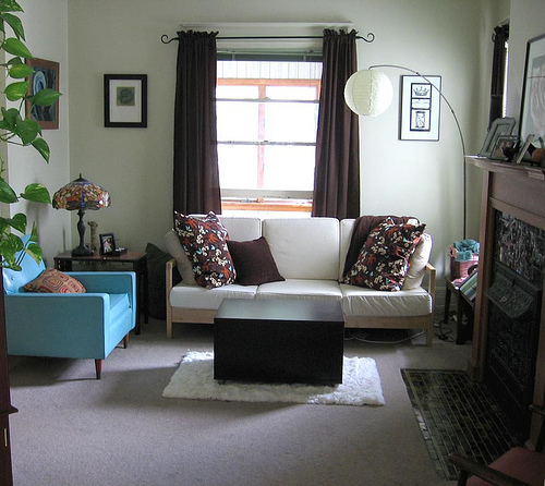 غرفة جلوس رائعة وبسيطة مكونة كنبة صغيرة وكرسي باللون اللبني