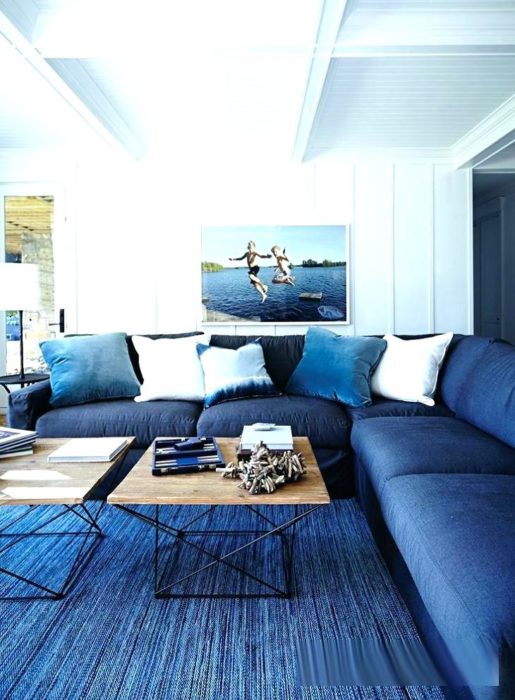 غرفة معيشة مكونة من ركنة باللون الازرق 2 ترابيزة خشبية بتصميم حلو جداً